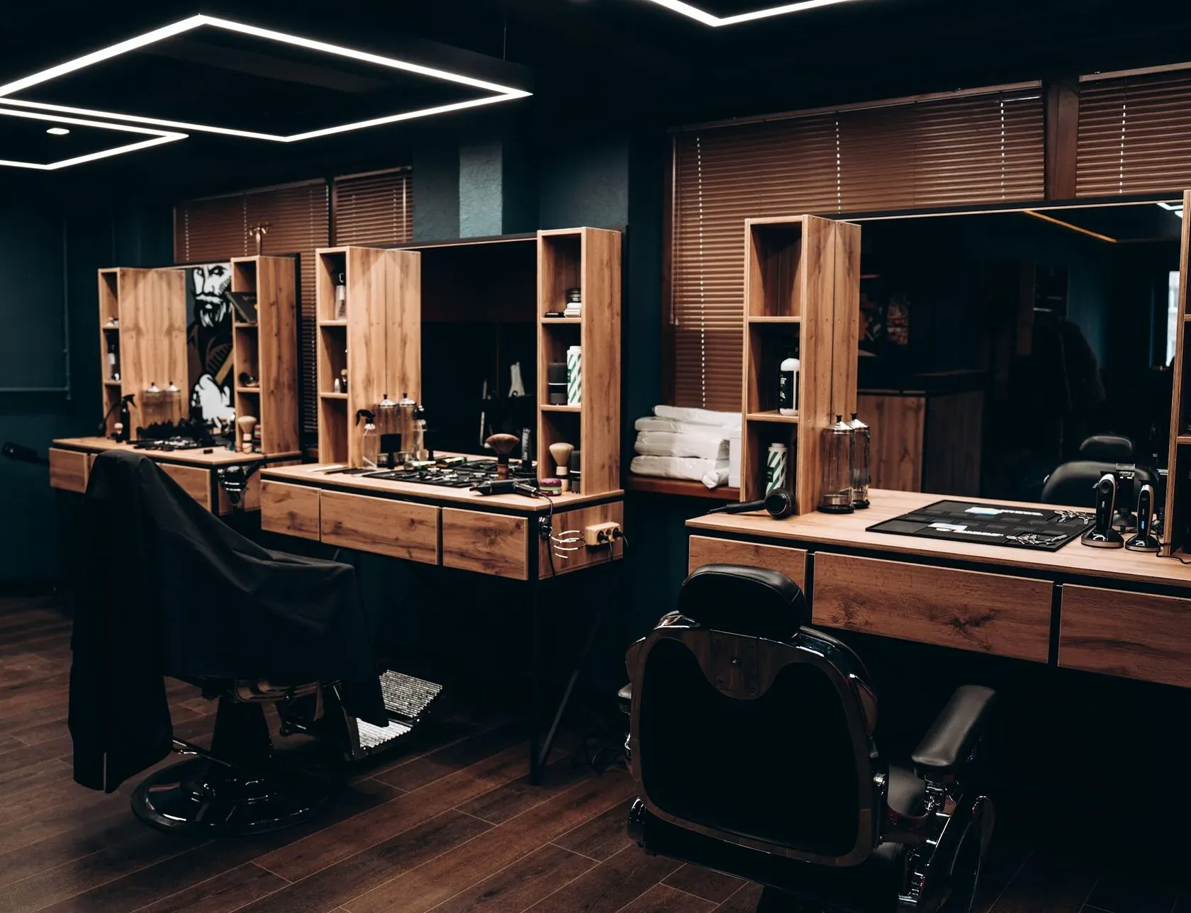 Интерьер зала Director Barbershop: рабочие места, дерево, зеркала